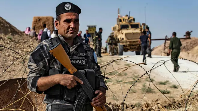 A member of Kurdish security forces stands guard during a demonstration by Syrian Kurds against Turkish threats