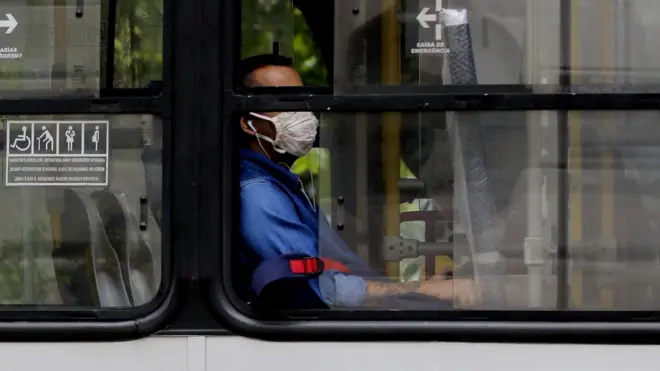 homem com máscara dentro de ônibus.