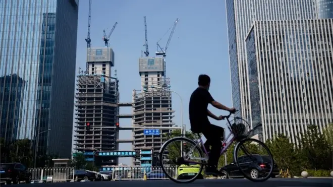 A man rides a bike along housing properties in Beijing, China, 15 September 2022.