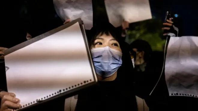 A protester holds a blank piece of paper