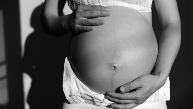 Foto em preto e branco da barriga de uma gestante