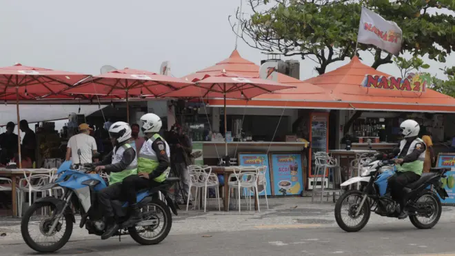 Policiais em motos passam em frente a quiosque onde médicos foram mortos no Rio