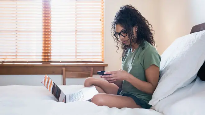 mulher trabalhando sentada na cama