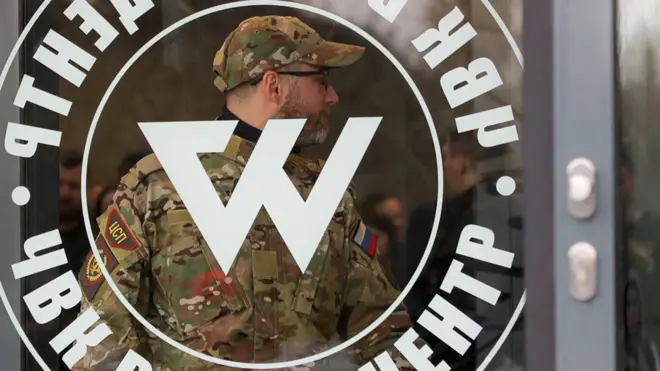 A man wearing a camouflage uniform walks out of PMC Wagner Centre during the official opening of the office block in Saint Petersburg,