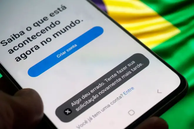 Celular com tela inicial do aplicativo X mostra mensagem de 'Algo deu errado' 