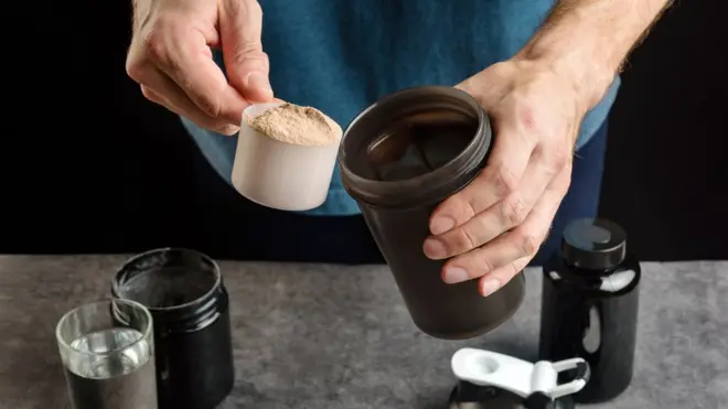 Homem preparando suplemento de proteína