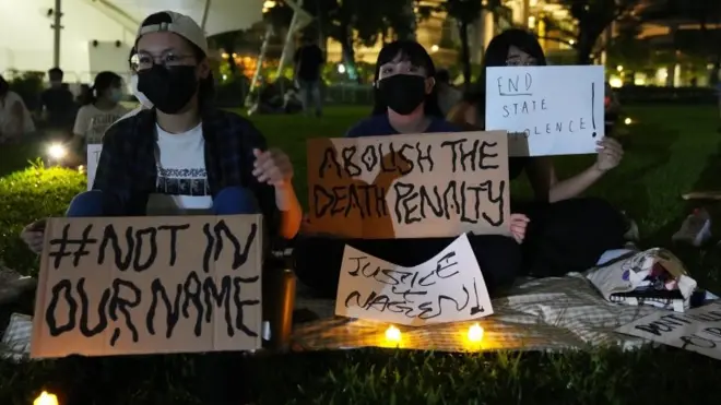 People hold candles and placards during a candlelight vigil against the death penalty for Malaysian national Nagaenthran K. Dharmalingam