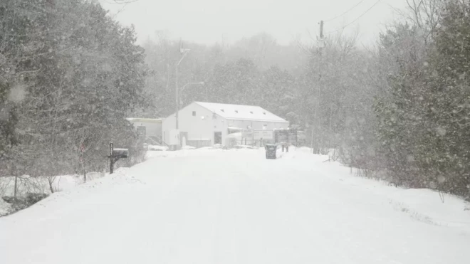 Paisagem de estrada cheia de neve com casa ao fundo