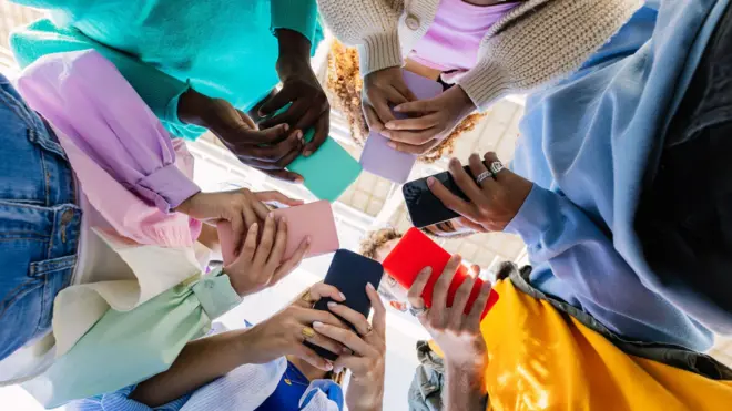 Roda de jovens olhando para celulares