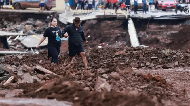 Pessoas andam em meio à destruição em Roca Sales, Rio Grande do Sul