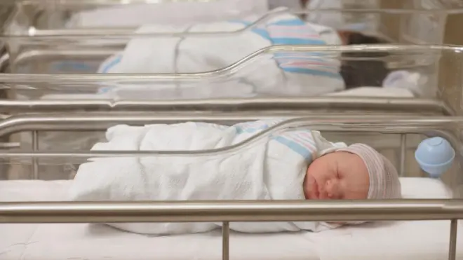 Bebês dormindo em berçário de maternidade