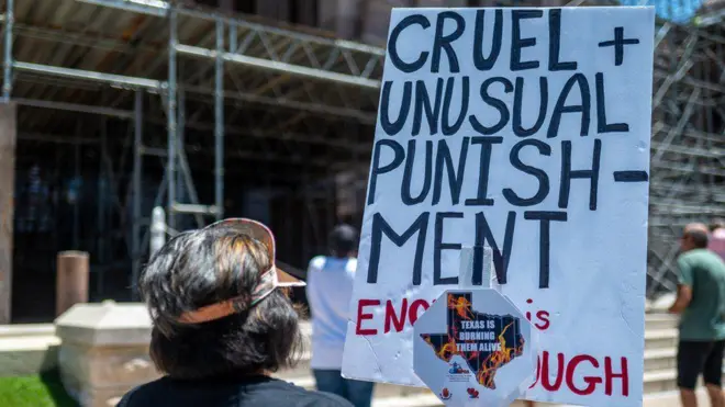 Pessoas segurando cartaz que fala em 'crueldade'