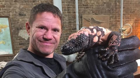 Steve Backshall holding a lizard.