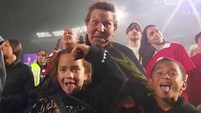 A crowd of people pull faces at a gathering to break the largest haka world record