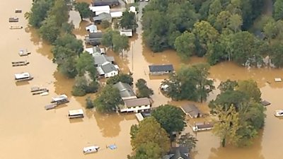 Aerial view of houses surrounded by brown floodwater