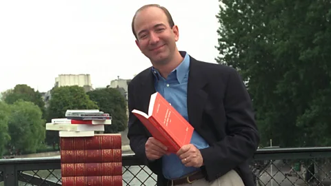 Jeff Bezos standing next to stack of books (Credit: Getty Images)
