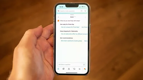 A hand holding a phone with Amazon's AI shopping assistant Rufus on the screen (Credit: Getty Images)