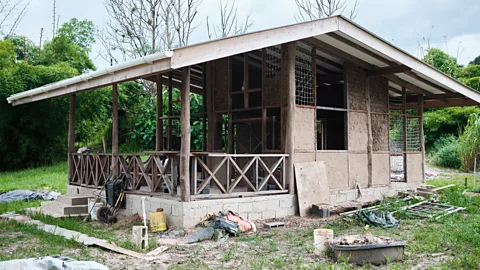 A house made of wood, clay and grass under construction (Credit: Damar Ali)