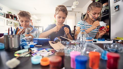 3 kids making art using plastic bottles