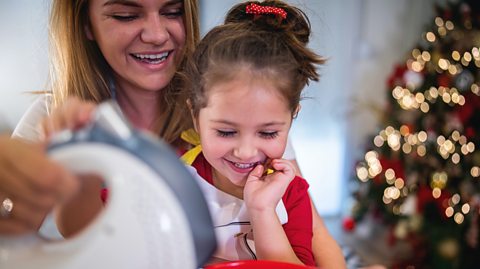 mother and daughter baking together in the kitchen at christmas