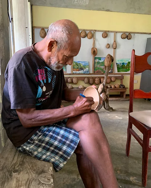 Jose Alison Kentish Faustulus Frederick works on a Calabash carving in the shelter he has called home since Hurricane Maria in 2017 (Credit: Jose Alison Kentish)