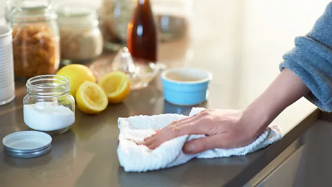 Getty Images Hand wipes countertop with a white cloth (Credit: Getty Images)