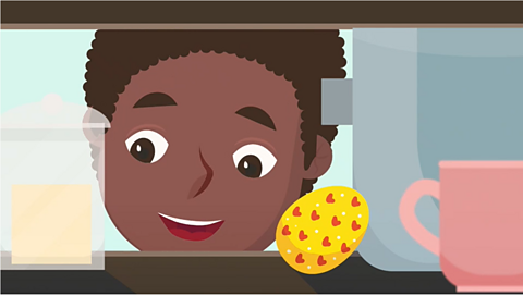 Image of a black child finding an Easter egg in the cupboard as part of an Easter egg hunt. 