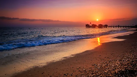 BBC Studios For Koç, a night out in Antalya has always meant one thing: raising a glass on the beach and having a night swim (Credit: BBC Studios)