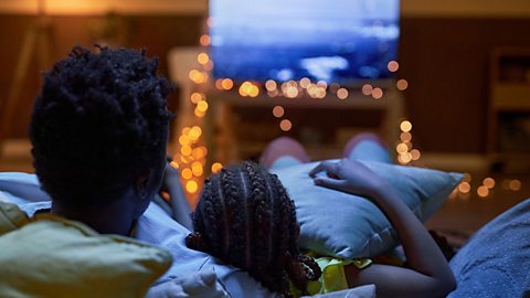 Father and child watching TV together.