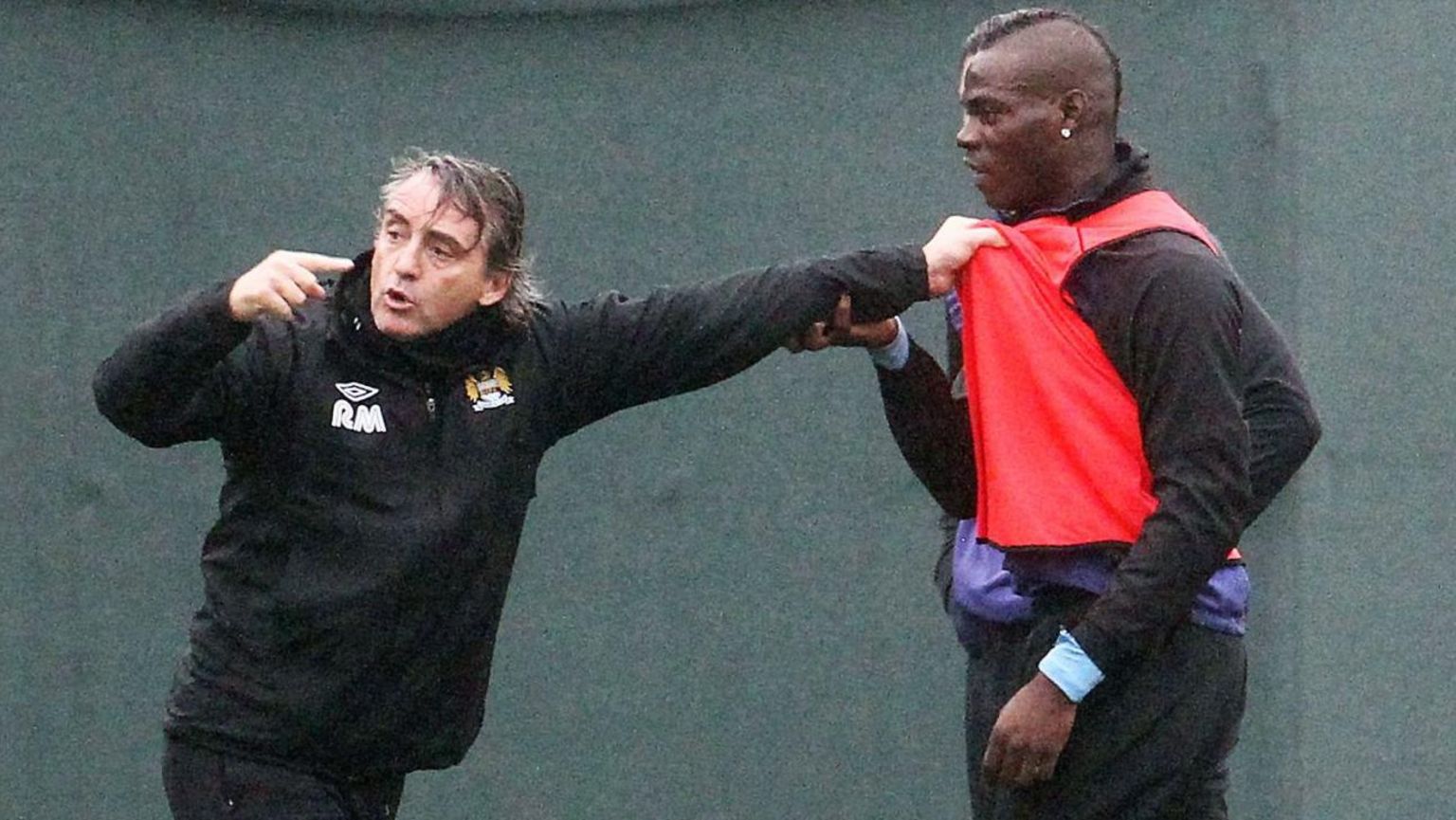 Roberto Mancini clutches Mario Balotelli's shirt