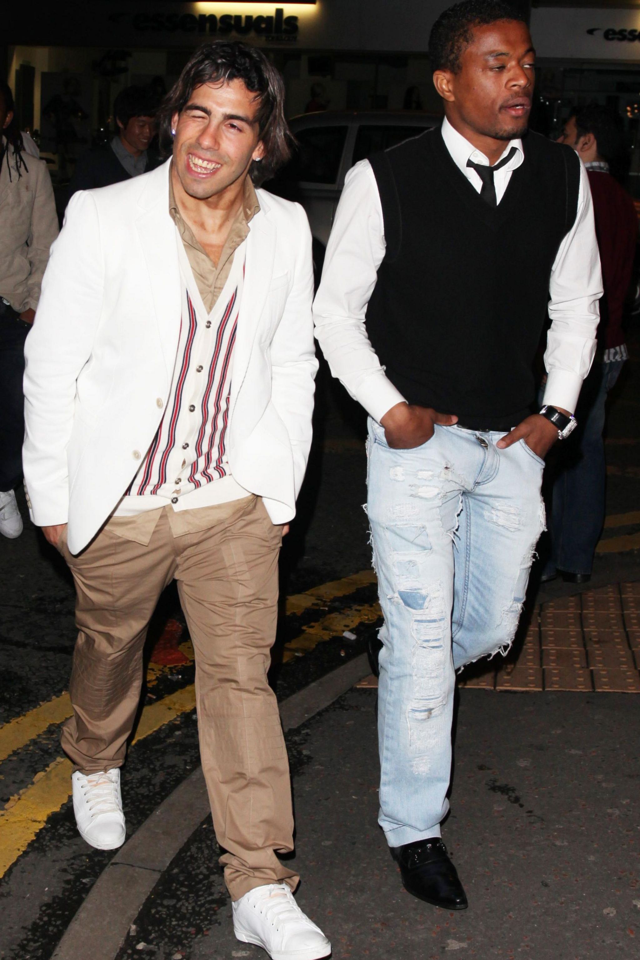 Carlos Tevez and Patrice Evra walk side by side on a night out