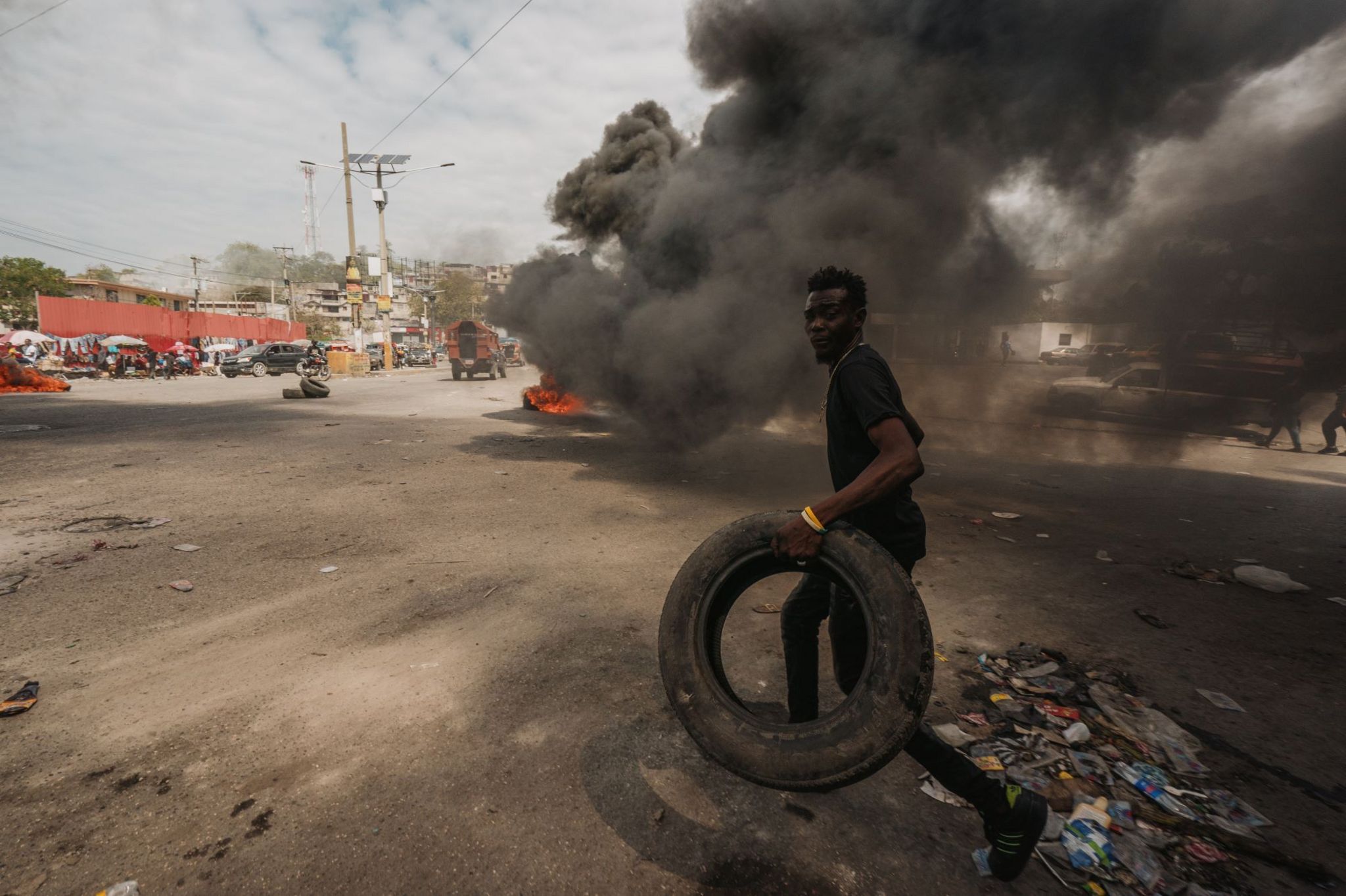 A man runs with a tyre in Port-au-Prince
