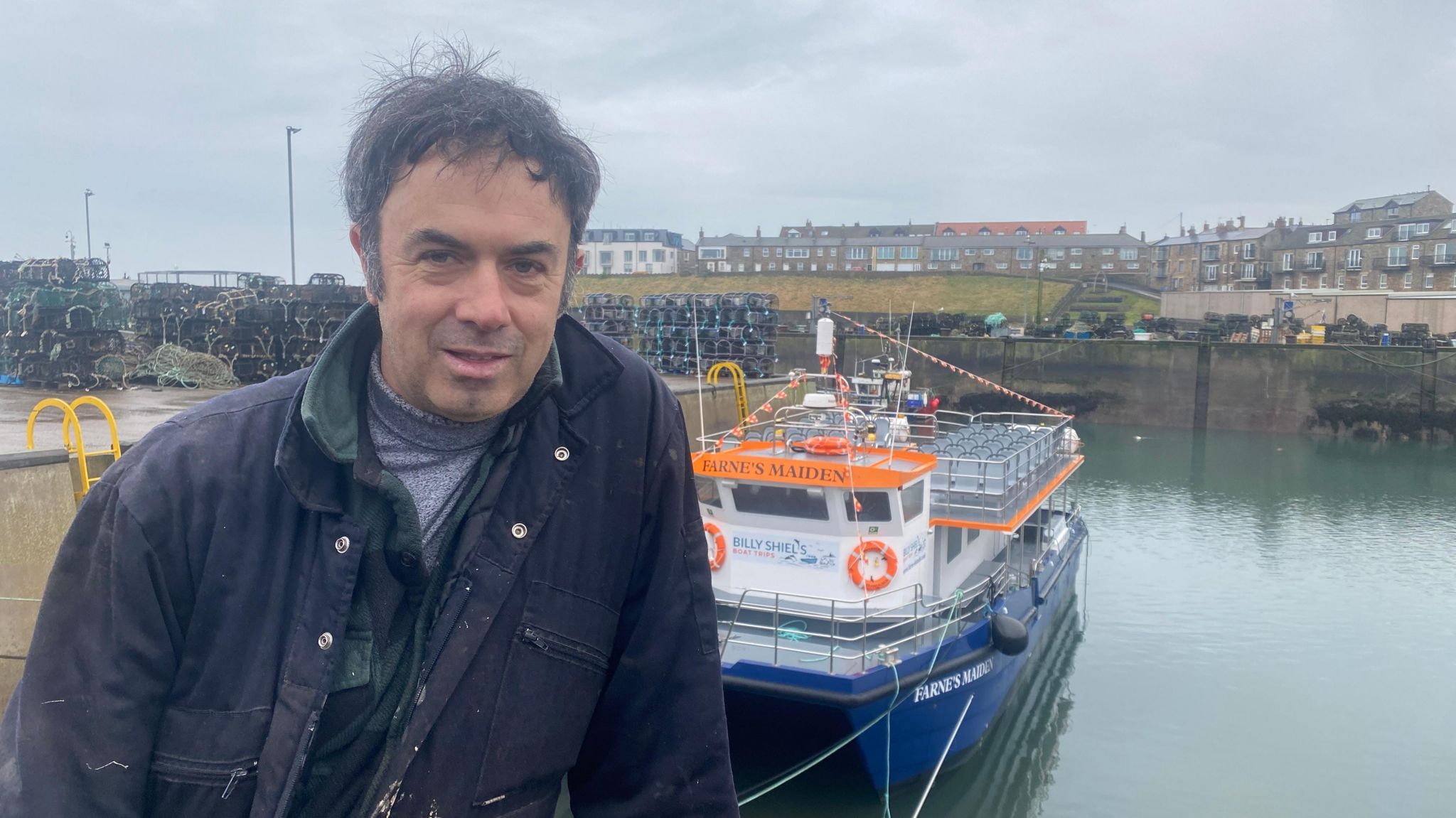 A skipper, William Shiel standing in front of his boat 