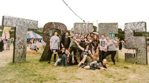 Gareth Bull A group of people in front of a festival sign