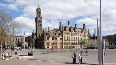 Bradford's City Park, with a large stone and concrete pond and fountains, and the Victorian Gothic City Hall behind.