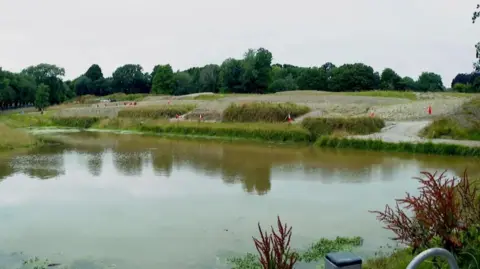 BBC Wide shot of a pond with traffic cones around the edges.