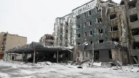 BBC/Imran Ali A dusting of snow is on the ground outside a ruined four-storey building in Pokrovsk in eastern Ukraine