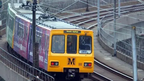 A Tyne and Wear Metro train travelling to South Hylton. The train is travelling on a bridge.