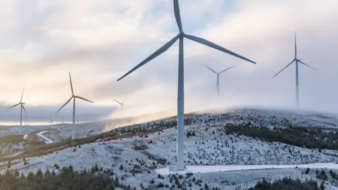 A wind farm seen in the UK in a snowy hilly region in South Lanarkshire.