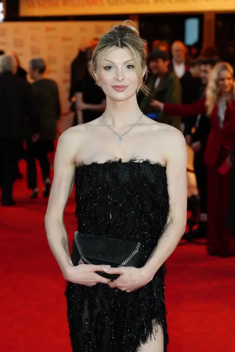 Ian West/PA Dylan Mulvaney wears black dress to The Devil Wears Prada Gala at Dominion Theatre, London