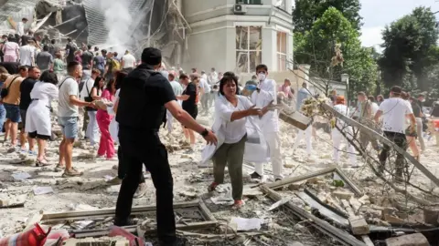 Staff at the Okhmadyt children's hospital form human chains to move rubble after the attack