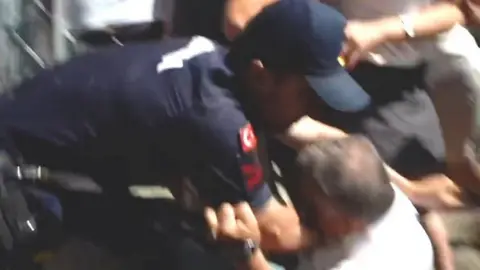 Police officer and protester scuffling on the floor