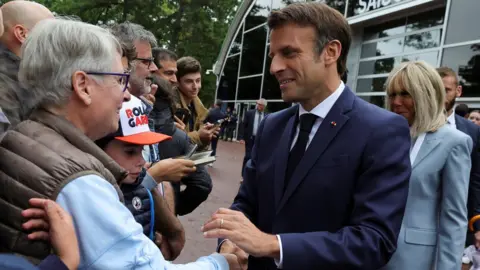 Reuters French President Emmanuel Macron greets supporters as he arrives to vote in the second round of French parliamentary elections, at a polling station in Le Touquet-Paris-Plage, France, June 19, 2022