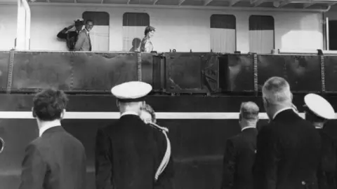 Getty Images The Queen and Duke of Edinburgh walking along the decks of the Royal Yacht Britannia at the end of their first day in Cardiff - 5 August 1960