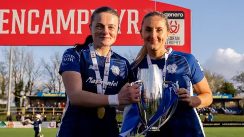 Cardiff City Womens' Ffion Price and Hannah Power celebrate winning the 2023/24 Genero Adran Trophy