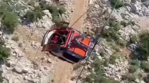 A red cable car seen from a helicopter