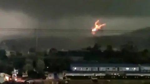 Fire erupts as tornado hits power lines