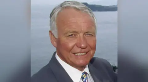 BBC Craig Rich smiling towards the camera with the sea in the background.