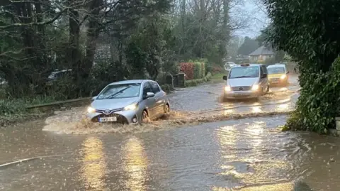 Cars drive through flood water  on the Isle of Wight