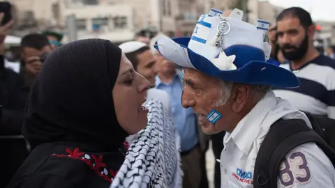 Getty Images A pro-Palestinian woman and a pro-Israeli man shouting at each other